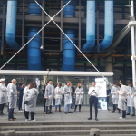 a group of people in lab coats gather outside the Pompidou Centre for Ling Tan's Pollution Explorers