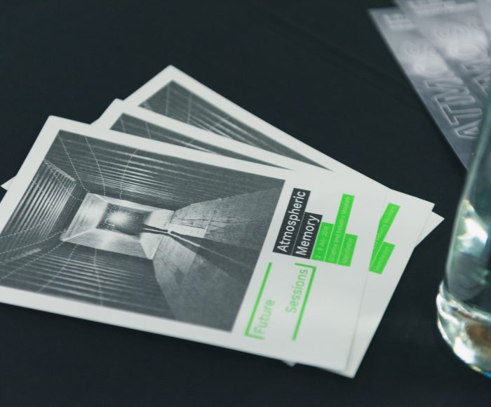 Two event flyers laid face up on a black table cloth, the flyers read Future Sessions Atmospheric Memory